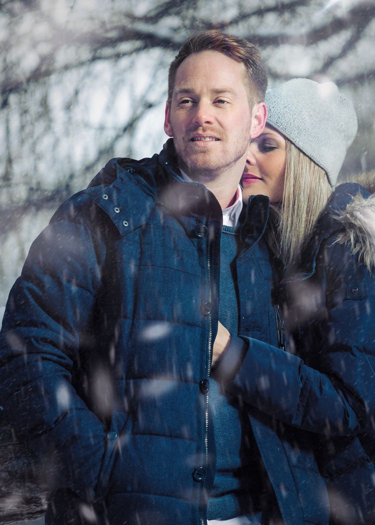Sie kuschelt sich an ihn im Schneetreiben. Foto mit Blitz.